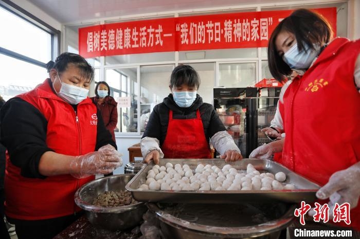 在泰安市泰山区邱家店镇王林坡村的幸福食堂，众多志愿者带领村里的库区移民包元宵。　陈阳 摄