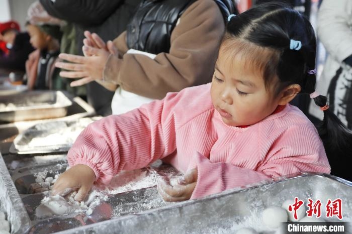 孩子参与包元宵庆祝元宵佳节。　陈阳 摄