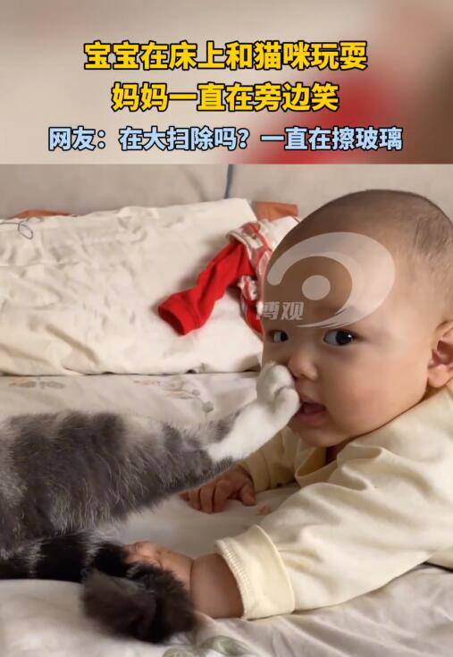 宝宝在床上和猫咪玩耍 妈妈一直在旁边笑