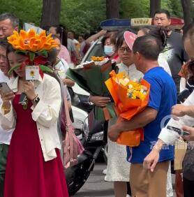 【视频】家长们在考场门口手持鲜花等待 网友：寓意满满 一举夺魁