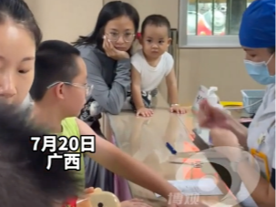 母子俩聚精会神看别的小孩打针
网友：原来看热闹也是遗传的 这眼神一模一样