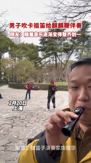 ​男子吹卡祖笛给麒麟鞭伴奏