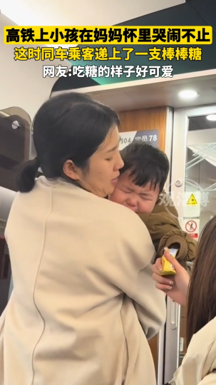 高铁上小孩在妈妈怀里哭闹不止，同车乘客递上了一支棒棒糖，样子好可爱