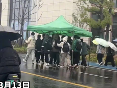 雨中的大学生撑着“大伞”行走