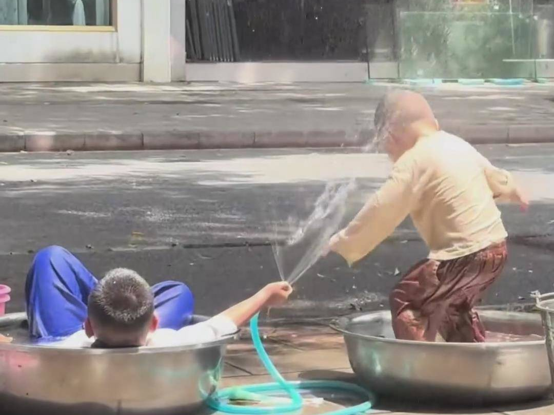 哥哥悠闲躺在水盆里，用水管为弟弟造了一场“雨”，网友：用心浇灌祖国的花朵
