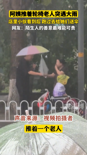 阿姨推着轮椅老人突遇大雨，小伙看到后跑过去给她们送伞