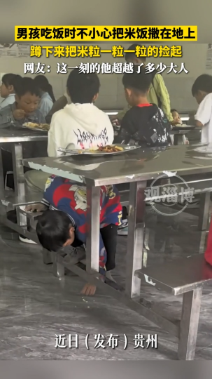 男孩吃饭时不小心把米饭洒在地上 蹲下来把米粒一粒一粒的捡起