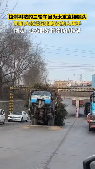 拉满树枝的三轮车因为太重直接翘头，司机大叔淡定和路过的人挥手