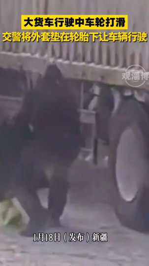 大货车行驶中车轮打滑，交警将外套垫在轮胎下让车辆行驶